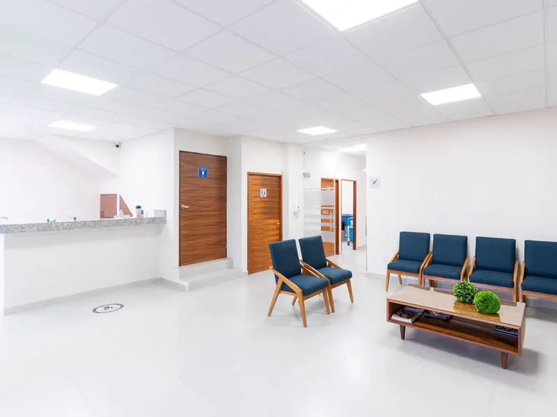 The clinic reception desk and waiting area, with chairs along the wall.